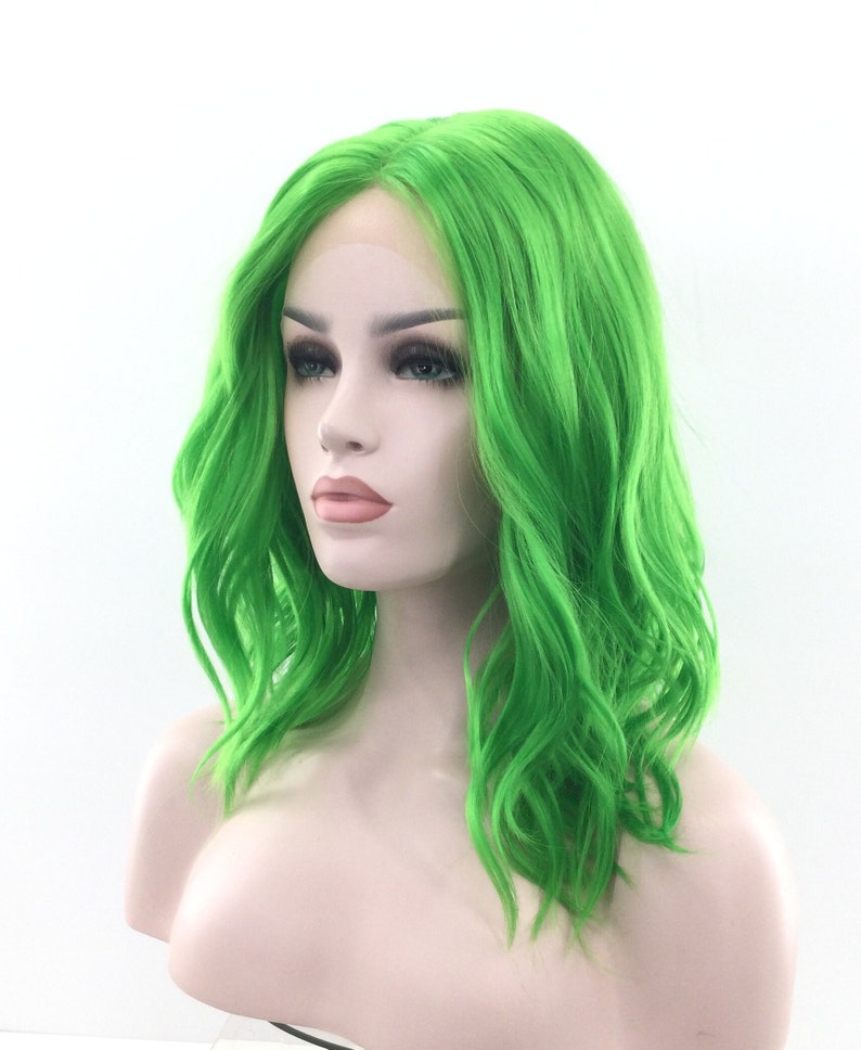 May include: A bright green, wavy synthetic wig with a lace front. The wig is styled in a shoulder-length bob with loose waves.