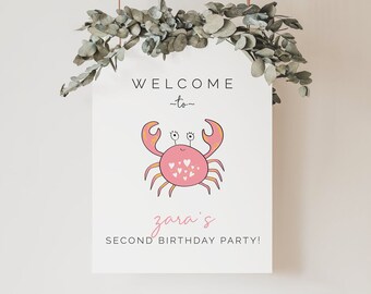 May include: White welcome sign with a pink crab illustration and the text "Welcome to Zara's Second Birthday Party!"