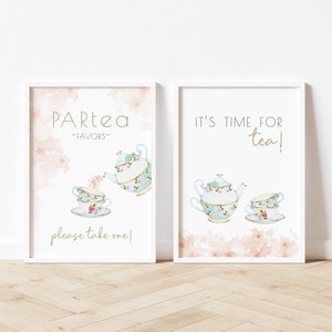 Könnte beinhalten: Zwei druckbare Schilder mit einem Tee-Party-Thema. Das erste Schild sagt "Partea - Favors - please take one!" und zeigt eine Teekanne, die Tee in eine Teetasse gießt. Das zweite Schild sagt "It's time for tea!" und zeigt eine Teekanne und eine Teetasse.