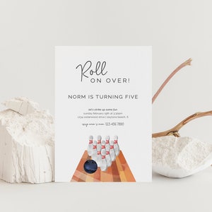 May include: A white invitation card with black text that reads "Roll on Over! Norm is turning five." The invitation includes details for a bowling-themed birthday party. The illustration features a bowling ball and pins.