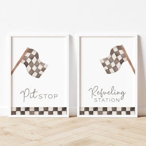 May include: Two white framed prints with black and white checkered flags and text. The left print says "Pit Stop" and the right print says "Refueling Station".