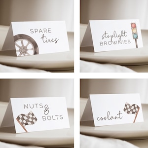 May include: Four white tent cards with watercolour illustrations and text. The cards read "Spare tyres", "Stoplight brownies", "Nuts & Bolts", and "Coolant". Each card has a corresponding image.
