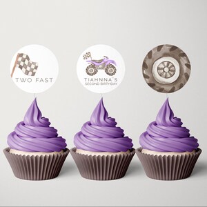 Könnte beinhalten: Drei Cupcakes mit lila Frosting und runden Toppern. Die Topper zeigen eine karierte Flagge mit dem Text "TWO FAST", ein ATV-Cartoon mit dem Text "TIAHNNA'S SECOND BIRTHDAY" und einen braunen Reifen mit schwarzem Felgenrand.