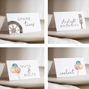 May include: Four white tent cards with watercolour illustrations and text. The cards read "SPARE tires", "stoplight BROWNIES", "NUTS & BOLTS", and "coolant". Each card has a different graphic, including a tyre, a traffic light, balloons, and more balloons.