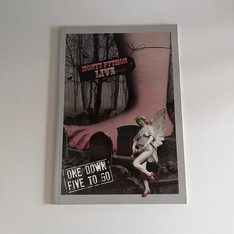 May include: A black and white image of a foot stepping on a graveyard. The foot is wearing a red ribbon tied around the ankle. A sign above the foot reads "Monty Python Live (mostly)". A statue of an angel with wings is standing on a tombstone. The text "One Down Five To Go" is on a sign in the bottom left corner.
