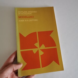 Puede incluir: Un libro amarillo con el título "Outline Studies in Ecology: Modelling" de John N.R. Jeffers. La portada presenta un gráfico rojo y naranja de cuatro flechas apuntando en diferentes direcciones.