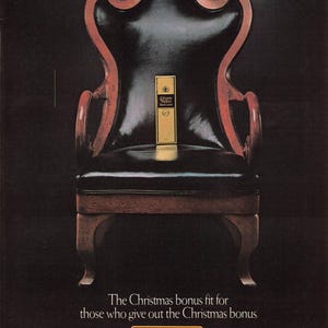 May include: An antique wooden chair with a black leather seat and back, featuring a gold label of Johnnie Walker Black Label Scotch. The chair has a dark wood frame with red accents. Text reads: "The Christmas bonus fit for those who give out the Christmas bonus."