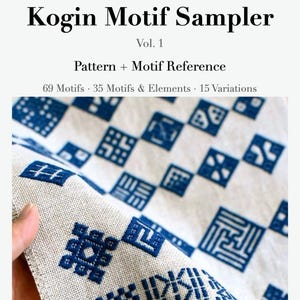 May include: A book titled Kogin Motif Sampler Vol. 1 Pattern + Motif Reference 69 Motifs 35 Motifs & Elements 15 Variations By Satonobou. The cover features a beige fabric with a repeating grid of blue geometric embroidery patterns.