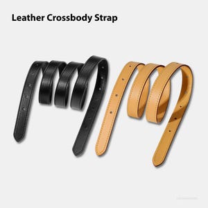 May include: Two leather crossbody straps, one black and one tan, are displayed against a light background. The straps are curled and have several holes for adjustment. The text "Leather Crossbody Strap" is at the top.