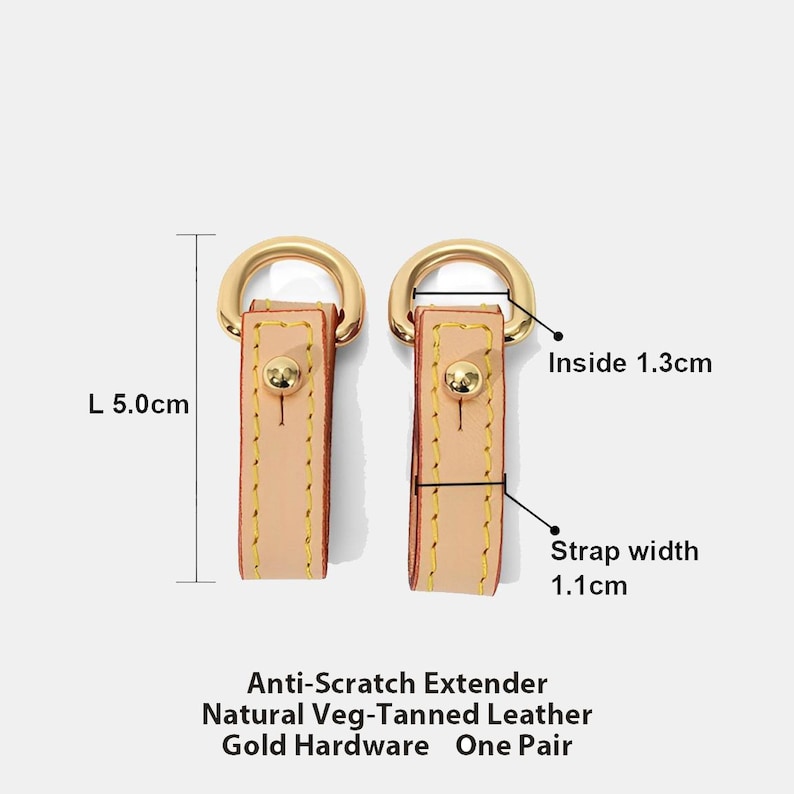 May include: Two natural veg-tanned leather strap extenders with gold hardware. Each extender is 5.0cm long, with a strap width of 1.1cm and an inside diameter of 1.3cm. The text reads: Anti-Scratch Extender, Natural Veg-Tanned Leather, Gold Hardware, One Pair.