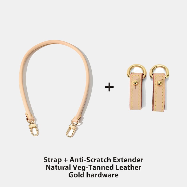May include: A light beige leather bag strap and two matching anti-scratch extenders with gold-colored hardware. The strap is curved, and the extenders are rectangular with gold-colored metal rings. The text at the bottom reads: Strap + Anti-Scratch Extender, Natural Veg-Tanned Leather, Gold hardware.