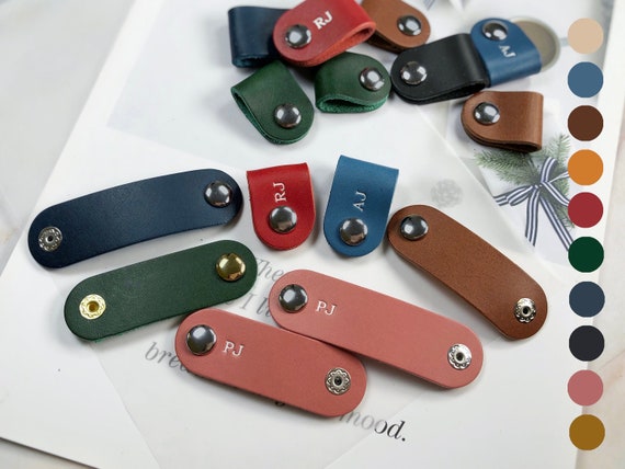 A slim veg-tanned leather headphone holder with a satisfying metal snap — 205 favorites signal real demand for this tidy, desk-beautifying craft piece.
