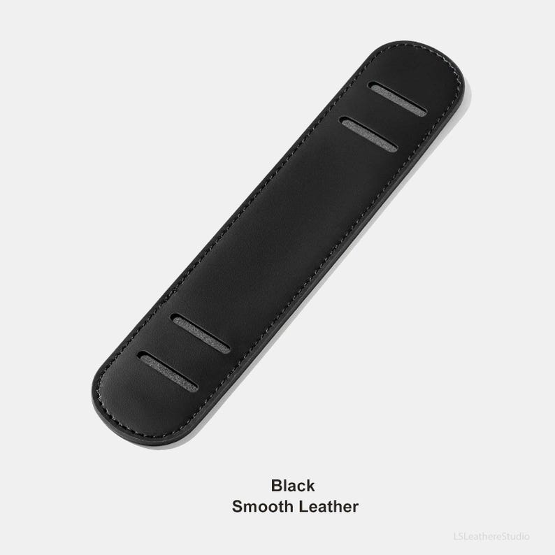 May include: A black, smooth leather shoulder pad with three rectangular slots. The text "Black Smooth Leather" is printed at the bottom of the image. The pad is designed to provide comfort and support.