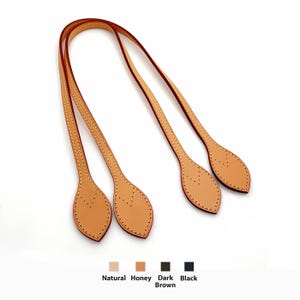 May include: Two honey-colored leather bag handles with stitched edges and leaf-shaped ends. Below the handles, four small color swatches are labeled Natural, Honey, Dark Brown, and Black, indicating available color options for the product.