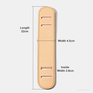 May include: A light tan leather shoulder strap pad with a length of 22cm, a width of 4.5cm, and an inside width of 2.8cm. The pad has three rectangular slots and is stitched around the edges.