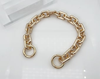 May include: A gold chain bracelet with a chunky link design and two circular clasps.