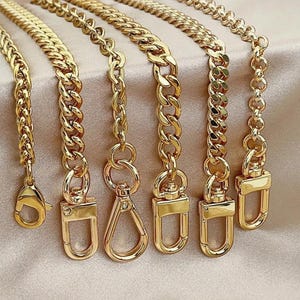 May include: A collection of six gold-toned metal chains of varying link styles and thicknesses, each finished with a different gold-toned metal clasp, including lobster claw, swivel, and rectangular spring-gate designs for attachment.