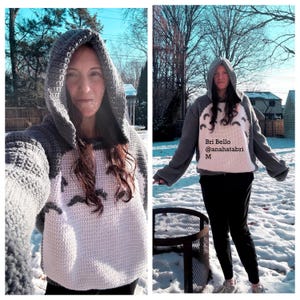 May include: A handmade crochet hoodie in gray and white. The hoodie features a hood and a design on the front. The text "Bri Bello @anahatabri M" is visible on the front of the hoodie.