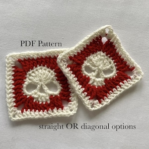 May include: Two crocheted white and red skull squares. The squares have a white skull design with red edging. The text "PDF Pattern" and "straight OR diagonal options" is visible below the squares.