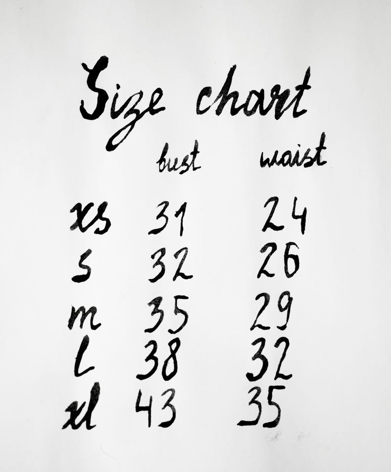 May include: A white size chart with black handwritten text. The chart lists sizes XS, S, M, L, and XL with corresponding bust and waist measurements in inches. The bust column shows 31, 32, 35, 38, 43 and the waist column shows 24, 26, 29, 32, 35.