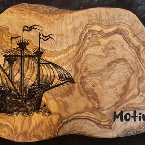 Könnte beinhalten: Ein Holztablett mit einer geschnitzten Abbildung eines Segelschiffs. Das Tablett hat eine natürliche Holzmaserung und der Text "Motiv 1" ist in die rechte untere Ecke geschnitzt.