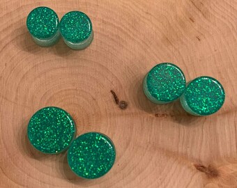 green forests plugsgauges green and black ear plugstretcher glitter plugs resin plugs bottle green