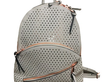 May include: A gray faux leather backpack with a star-shaped cut-out pattern and rose gold zippers.