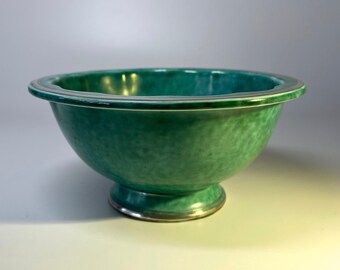 May include: A green ceramic bowl with a silver rim and a pedestal base. The bowl has a speckled glaze.