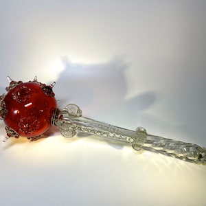 以下が含まれることがあります： 片側に赤い模様の球体、反対側に透明なねじれたガラスの柄が付いたガラスの笏