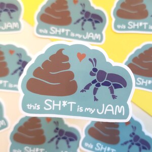 May include: A set of stickers featuring a cartoon poo emoji with a beetle and the text "this SH*T is my JAM". The stickers are on a yellow surface.