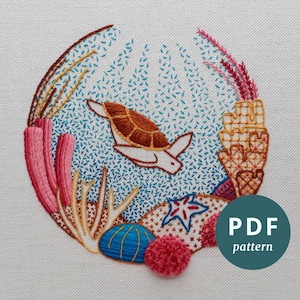 May include: A circular embroidery pattern featuring a sea turtle swimming in a blue ocean with coral, starfish, and seashells. The pattern is labeled "PDF pattern".