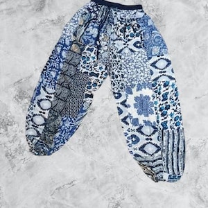 Könnte beinhalten: Blaue und weiße gemusterte Hose mit Kordelzug. Die Hose hat ein Patchwork-Design mit verschiedenen geometrischen und floralen Motiven.