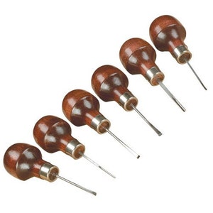May include: Set of seven wood carving tools with brown wooden handles and metal tips.