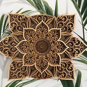 May include: A brown wooden mandala with intricate laser-cut designs. The mandala has a flower-like shape with multiple layers of detailed patterns.