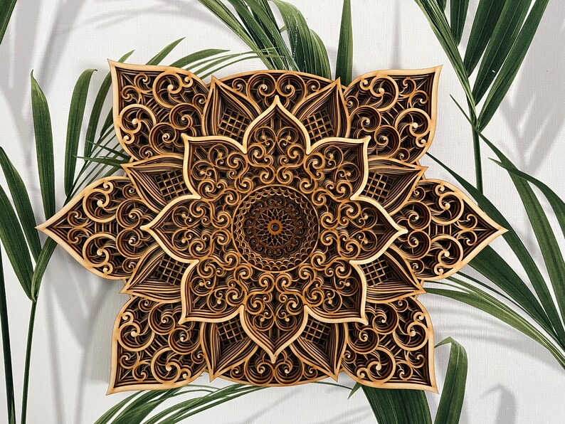 May include: A brown wooden mandala with intricate laser-cut designs. The mandala has a flower-like shape with multiple layers of detailed patterns.