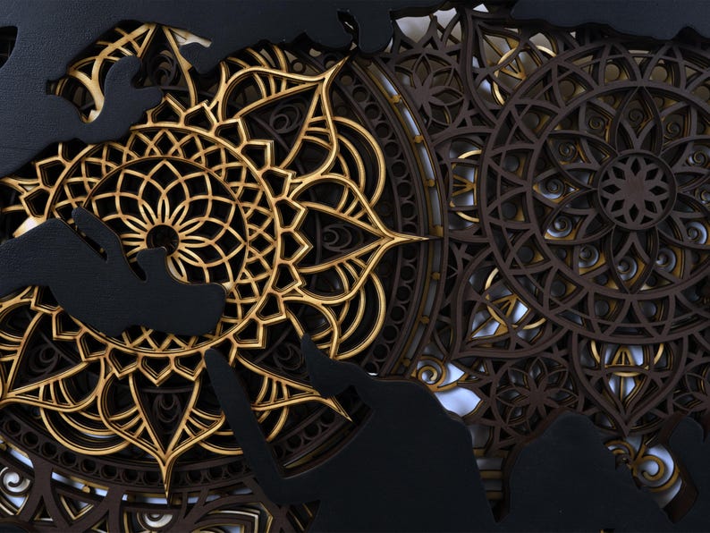 Puede incluir: Un dise&ntilde;o de mandala negro y dorado con detalles intrincados. El mandala est&aacute; hecho de madera y tiene un efecto de capas.
