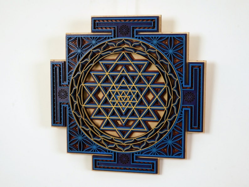 May include: A blue and gold Sri Yantra mandala wall art made of wood. The intricate design features a geometric pattern with multiple layers.