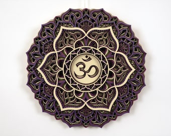 May include: A layered wooden mandala with a purple and brown color scheme. The center of the mandala features the Om symbol in a cream color.