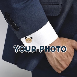 May include: A navy blue suit with a white dress shirt cuff featuring a pair of cufflinks. The cufflinks have a cat face design wearing a panda hat. The text "YOUR PHOTO" is displayed in white.
