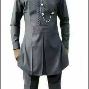 May include: A charcoal grey two-piece suit. The long-sleeved tunic features a mandarin collar, decorative stitching, and a silver chain with three silver beads. The matching trousers have a straight leg design. This outfit is suitable for formal occasions.