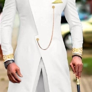 May include: White suit with gold accents. The long-sleeved jacket features a mandarin collar, gold buttons, and a decorative chain. The cuffs and collar have gold embroidery. The suit is paired with matching white pants.