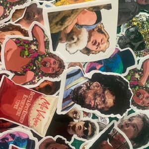 May include: A collection of colorful stickers featuring various characters and designs. The stickers include a sunflower, a cartoon character with a red shirt, a chip bag, and a character with a blue shirt and a bandage on their face.