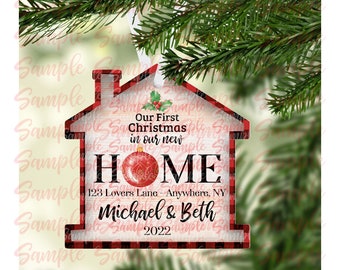 May include: Red and black plaid house-shaped Christmas ornament with the text "Our First Christmas in our new HOME 123 Lovers Lane - Anywhere, NY Michael & Beth 2022".