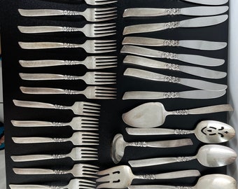 May include: A set of silver flatware with ornate handles. The set includes forks, knives, spoons, and serving utensils.