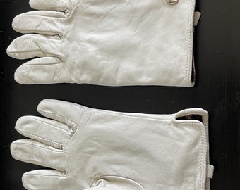 May include: A pair of white leather gloves with a small silver logo on the cuff.