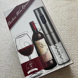 May include: A silver electric wine opener with a black and white illustration of a wine bottle and glass on the box. The box says "Electric Wine Opener" and "Uncle Vine".