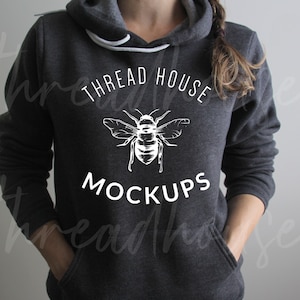 May include: A dark gray hoodie with a white bee and the text "THREAD HOUSE MOCKUPS" printed on the front.