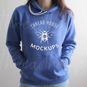 May include: A royal blue hoodie with a white bee graphic and the text "THREAD HOUSE MOCKUPS" printed on the front.