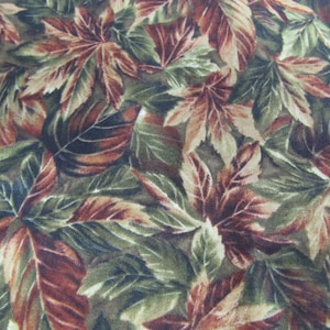 May include: A fabric featuring a dense, repeating pattern of autumn leaves in shades of deep forest green, olive, and warm rust-brown. The design displays overlapping maple-style foliage with visible veins and textured details across the surface.