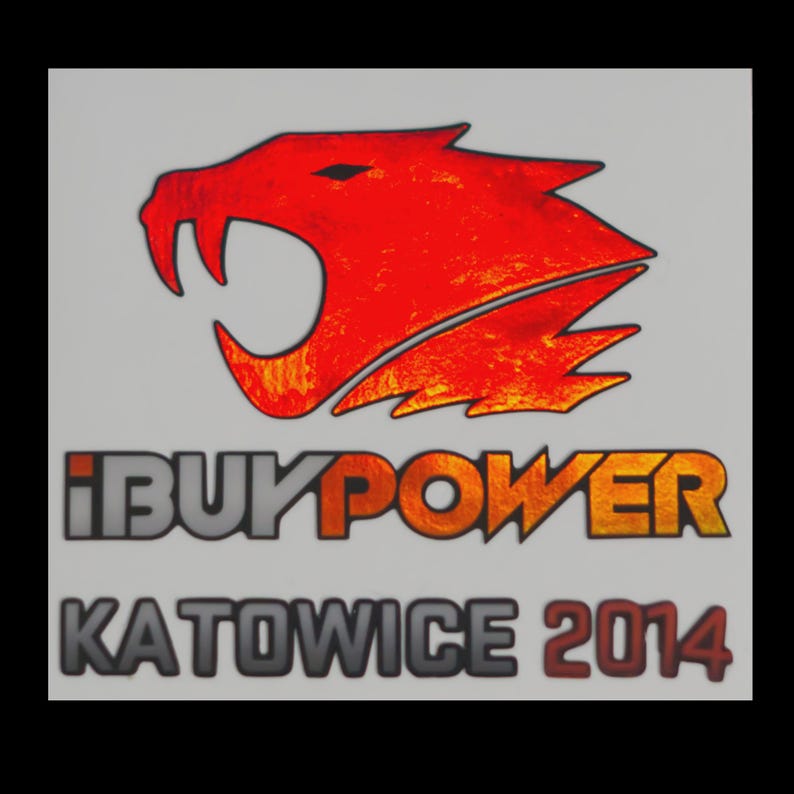 May include: A graphic sticker featuring a stylized red and orange snarling creature head logo above the text IBUYPOWER in a bold font, followed by the text KATOWICE 2014 in a dark grey and red font against a light grey background.